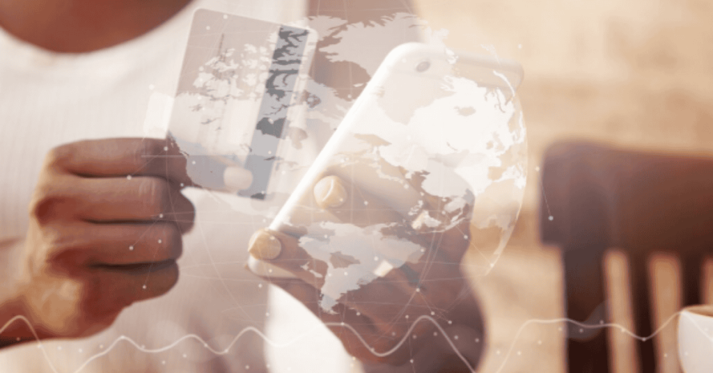 Mão segurando cartão e celular, representando finanças digitais e pagamentos online.